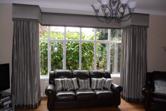 Dress your large square bay window with a simple but stylish curtain pelmet. This has contrasting fabric panels top and bottom to add interest.